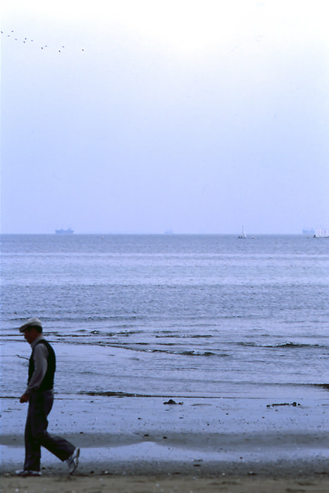 Old man walking beach