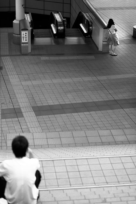 boy on stairway and woman beside escalator