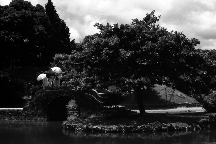 Three umbrellas on stone bridge
