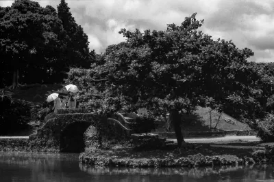 Three umbrellas on stone bridge in Shikinaen garden