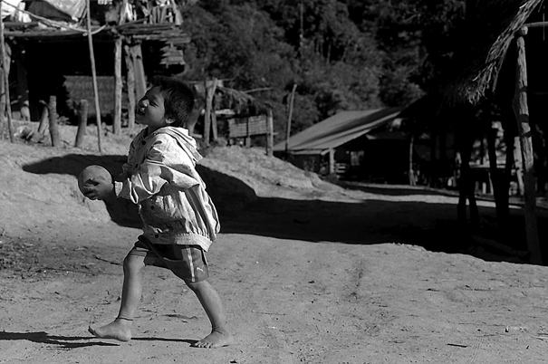 Shoeless boy playing with ball