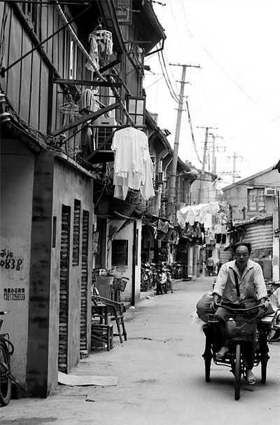 Man pedaling tricycle with luggage carrier