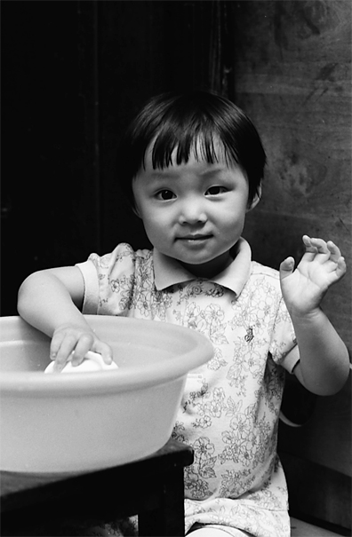 Bobbed-hair girl playing alone in lane