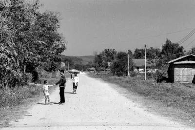 Two boys and one woman on dirt road