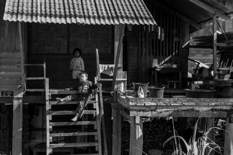 Boy sitting on wooden staricase