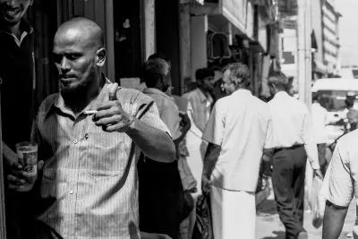 賑わっている道で親指を立てる男