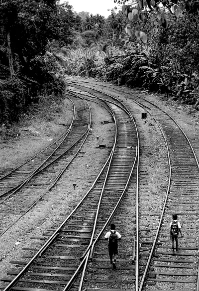 school boys walking on railway track