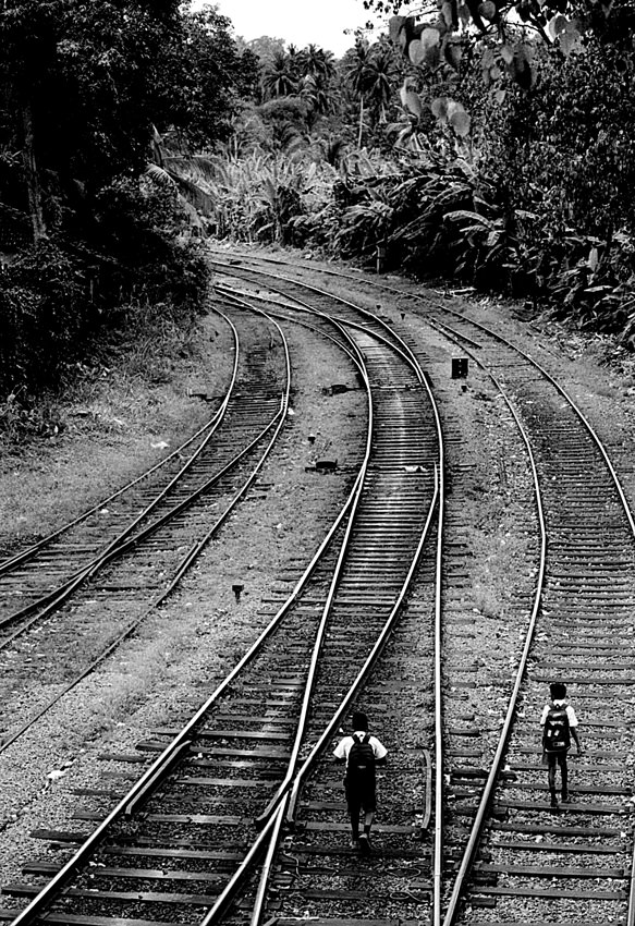 school boys walking on railway track