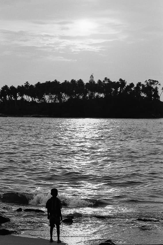 Boy watching island from the beach