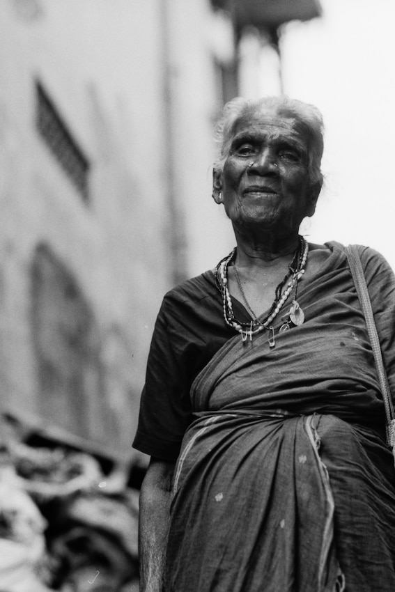 Older woman walking with saree and necklace