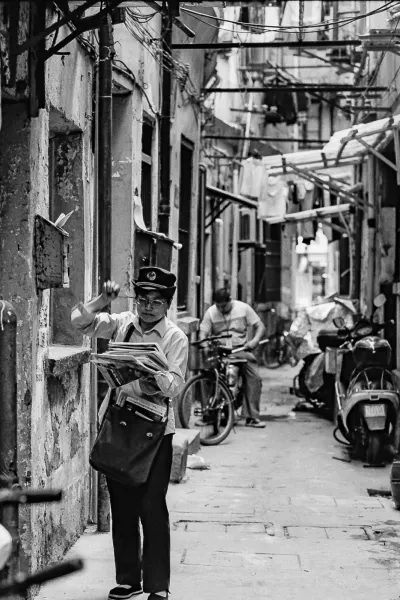 路地で配達する郵便配達の女性