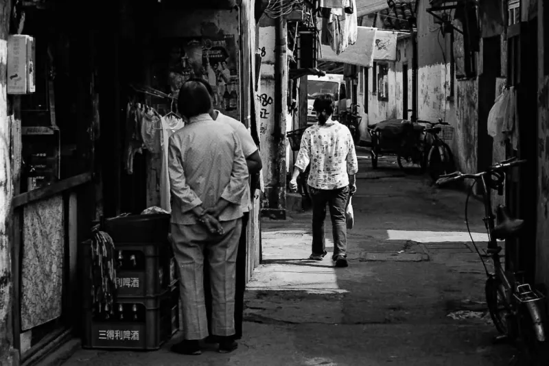Two persons standing talking in mazy lane