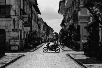 Silhouetted motorbike running stone paved street