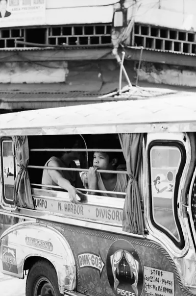 Boy looking into distance from jeepney