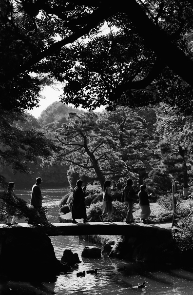 石橋の上のシルエットになった来園者