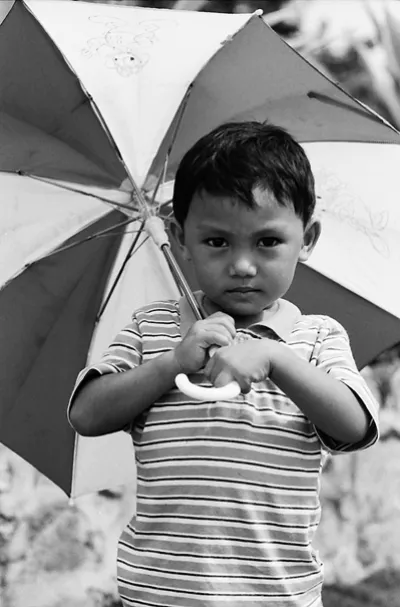 Boy holding striped umbrella