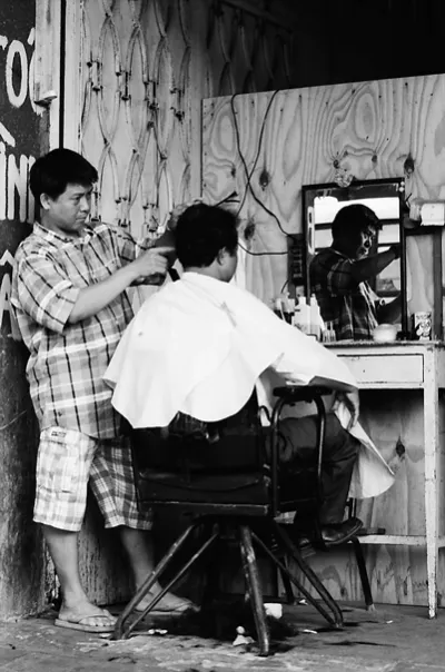 Barber cutting with serious face