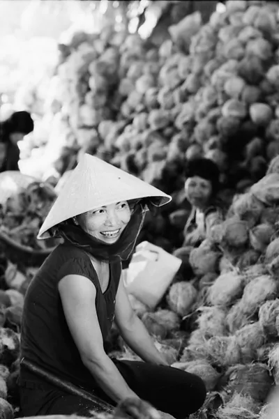 Woman smiling beside coconuts