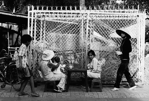 People Around A Plastic Table On The Sidewalk (Vietnam)