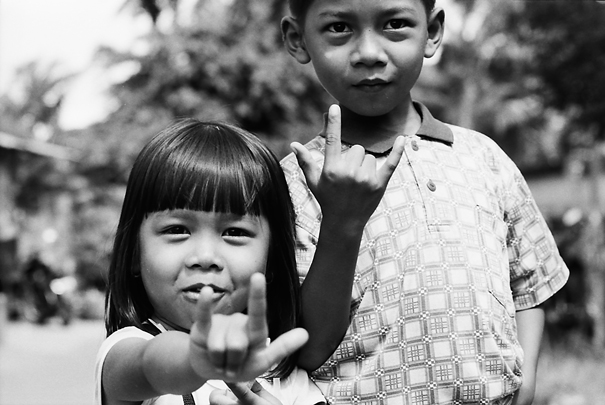 Siblings raising index finger and little finger