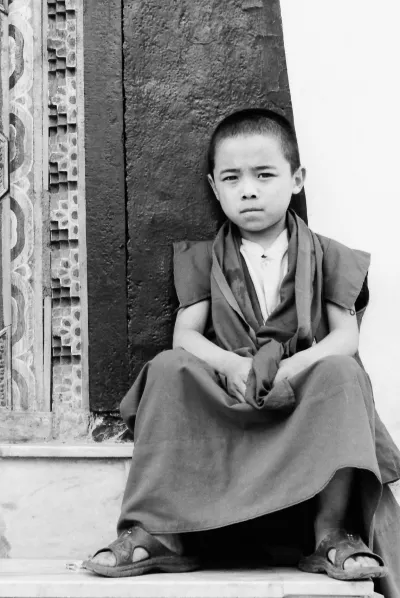 Little Buddhist monk sitting on steps