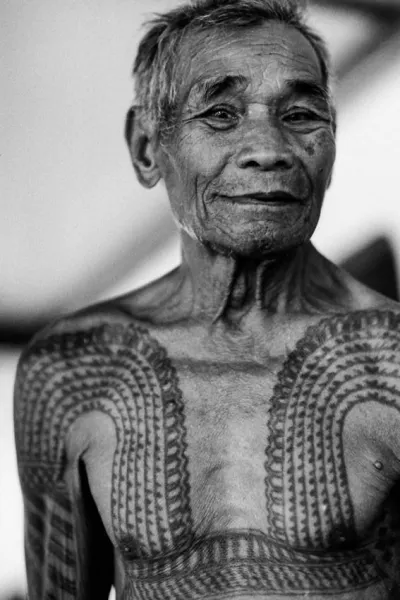 Old man showing tattooed chest