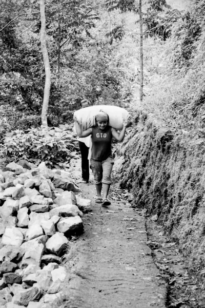Woman carrying burden on shoulder