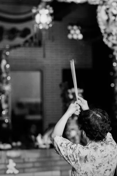Woman praying with long incense sticks