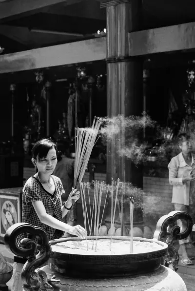 Woman sticking some long incense stick