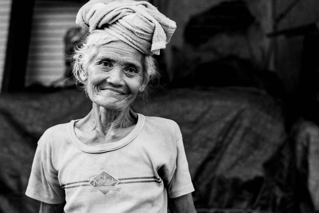 Older woman putting cushion on head