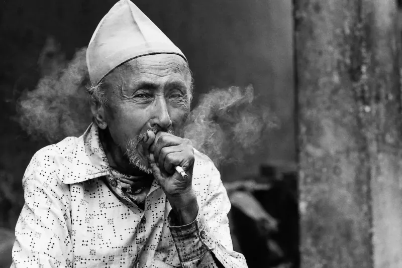 Man smoking cigarette in street corner