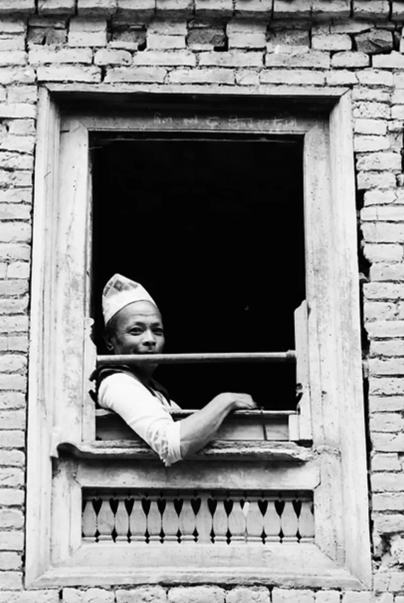 Man sitting by upstairs window