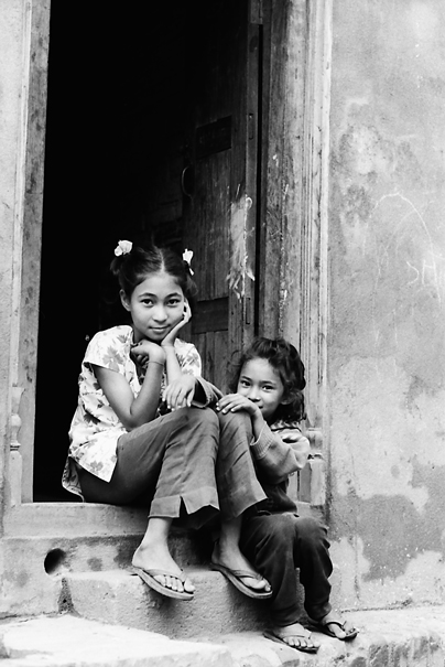 Sister sitting together in front of door