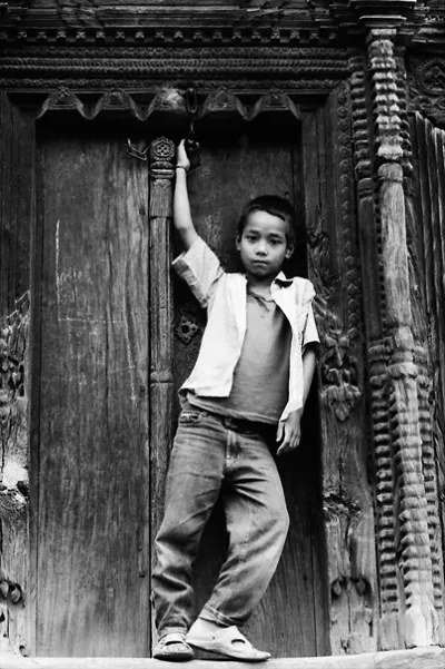 Boy striking pose in front of wooden door