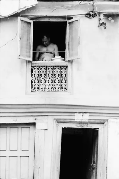 Man cooking by upstairs window