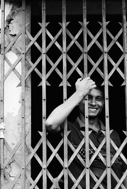 Man smiling on the other side of shutter