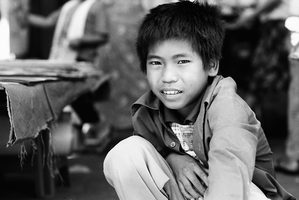 Boy squatting by wayside