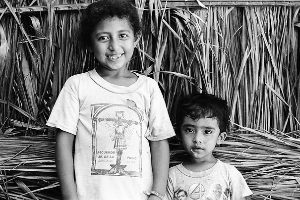 Siblings Standing In Front Of The Fence (Mexico)