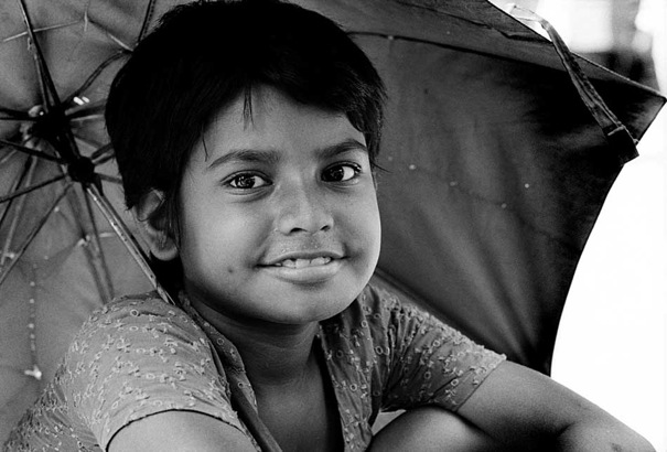 Girl smiling under umbrella