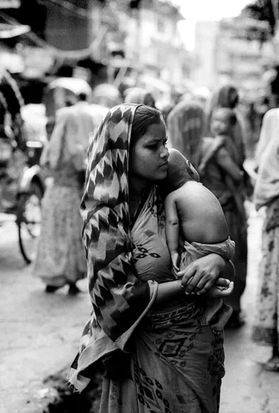 Closeup Young mother wearing saree carrying infant in sling