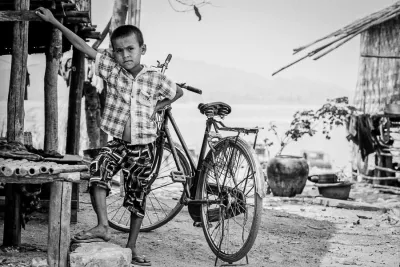 Boy posing in front of a bicycle