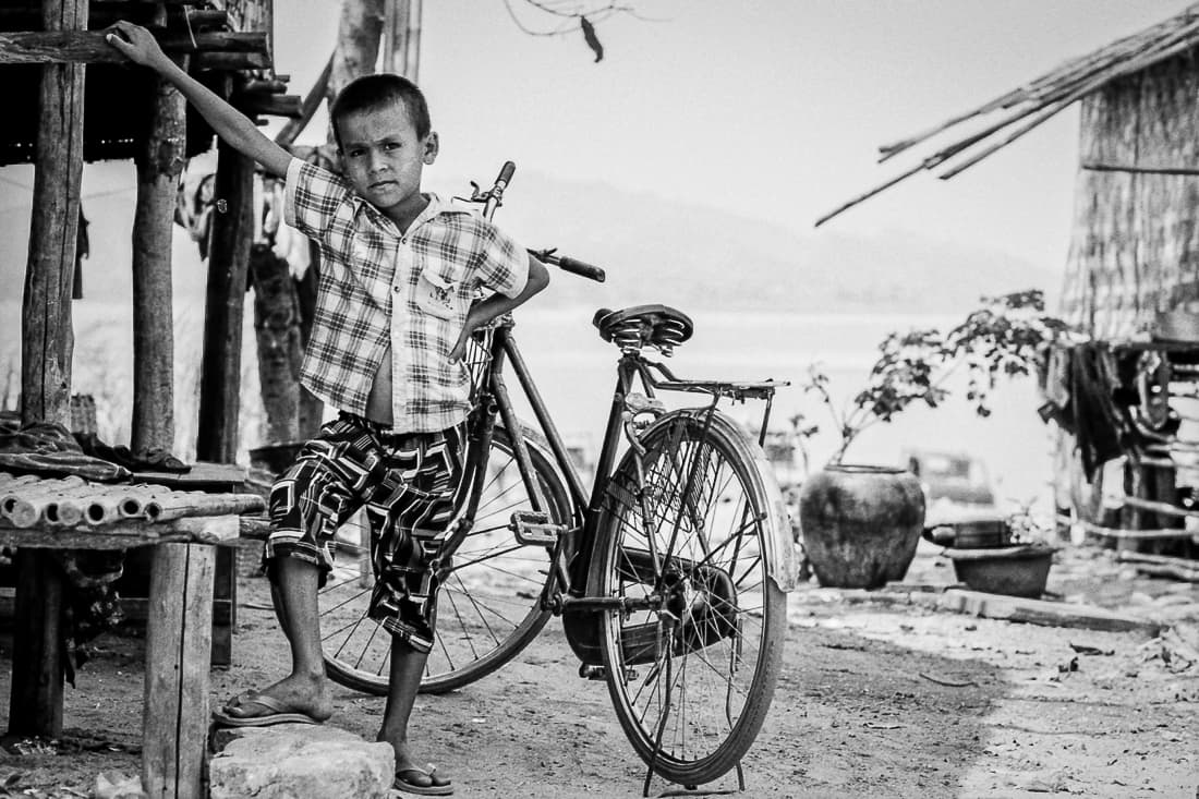 Boy posing in front of a bicycle