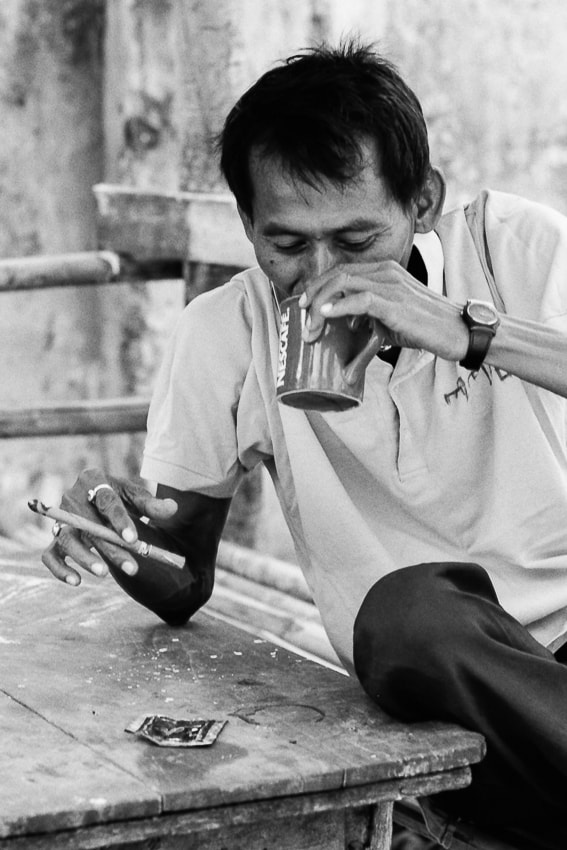 Man smoking a cigar and drinking coffee