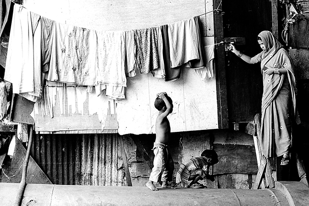 Mother And Kids In Front Of A House (India)