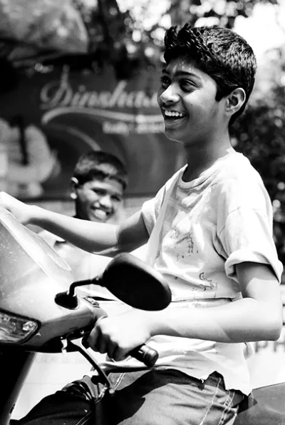 オートバイの上で笑う青年