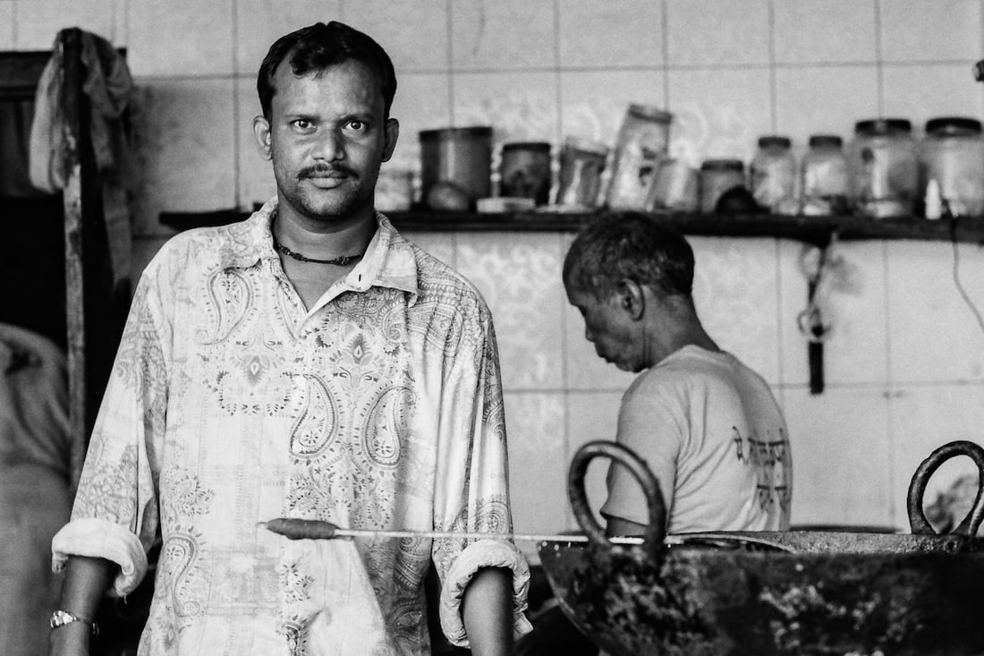 Man standing by a pot making samosas
