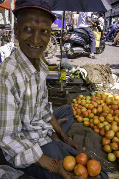 トマトを売るティラカを付けた年配の男