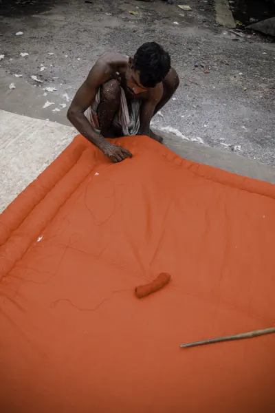Man sewing big red cushion