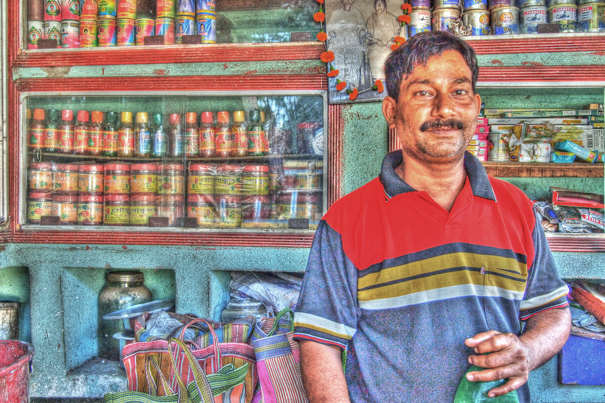 Man Standing In Front Of A Display Shelf (India)