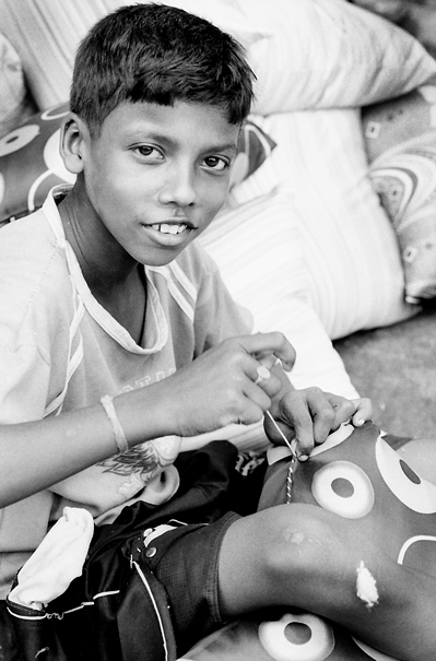Sewing Boy And A Heap Of Cushions (India)